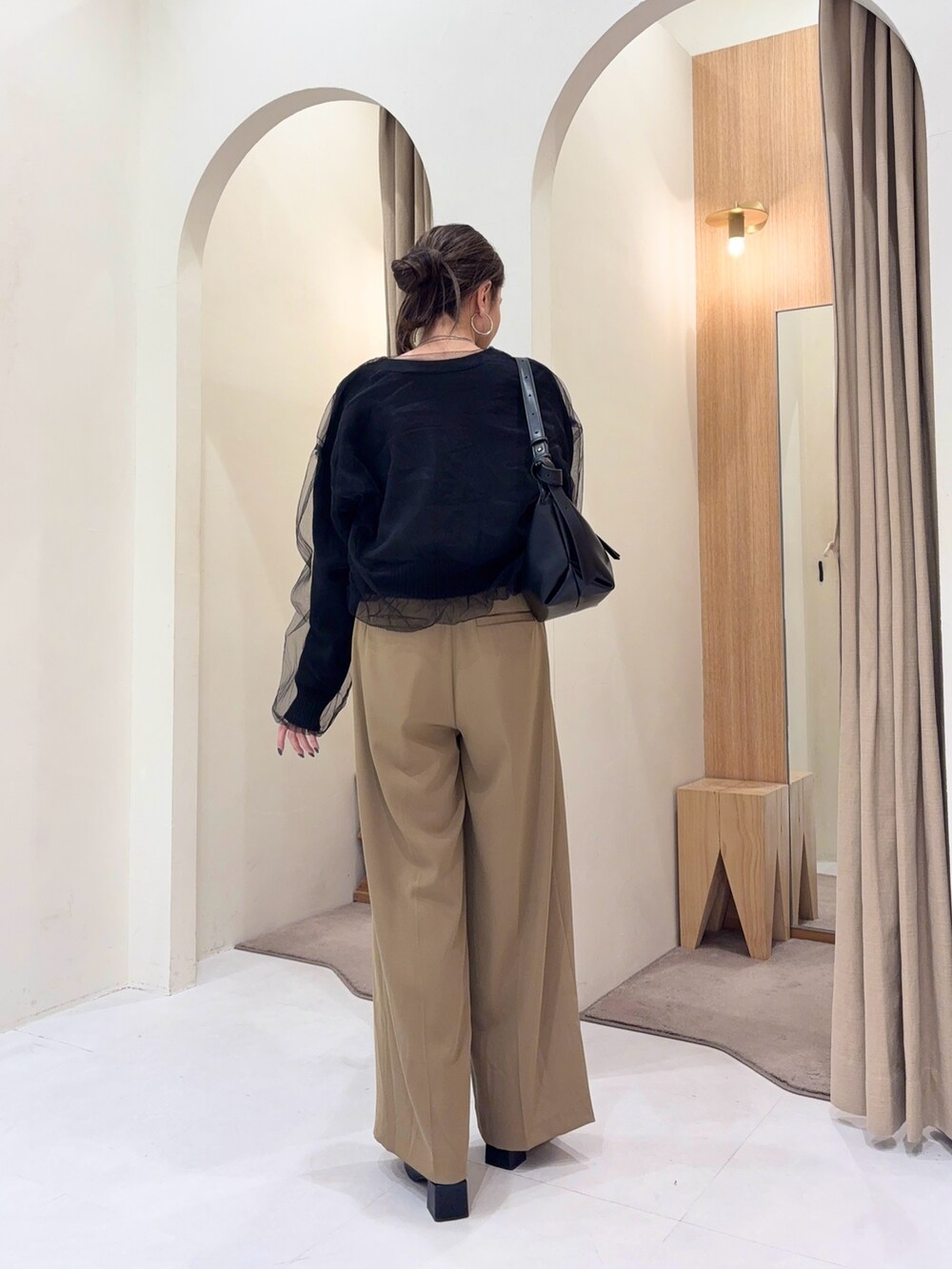 ブラック系のTシャツ/カットソー、ブラック系のカーディガン/ボレロ、ブラック系のショルダーバッグを着用したレディースの冬コーディネートの4枚目の写真