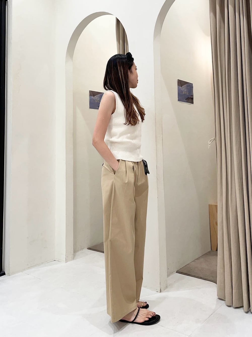 ホワイト系のニット/セーター、ベージュ系のその他パンツ、ブラック系のパンプスを着用したレディースの夏コーディネートの2枚目の写真
