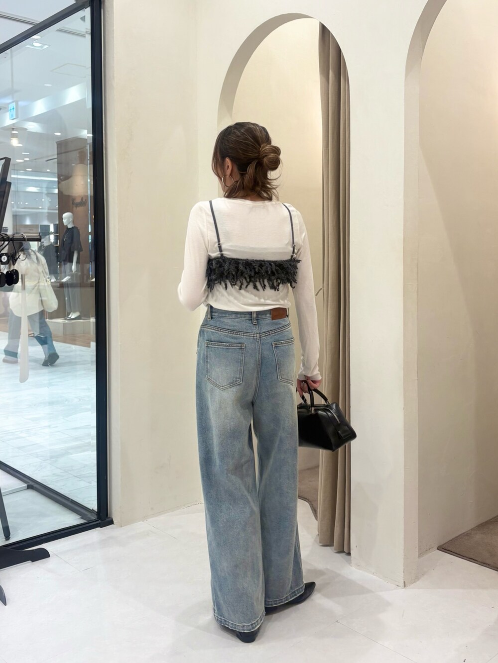 グレー系のTシャツ/カットソー、ブルー系のデニムパンツ、ブラック系のボストンバッグを着用したレディースの秋コーディネートの3枚目の写真