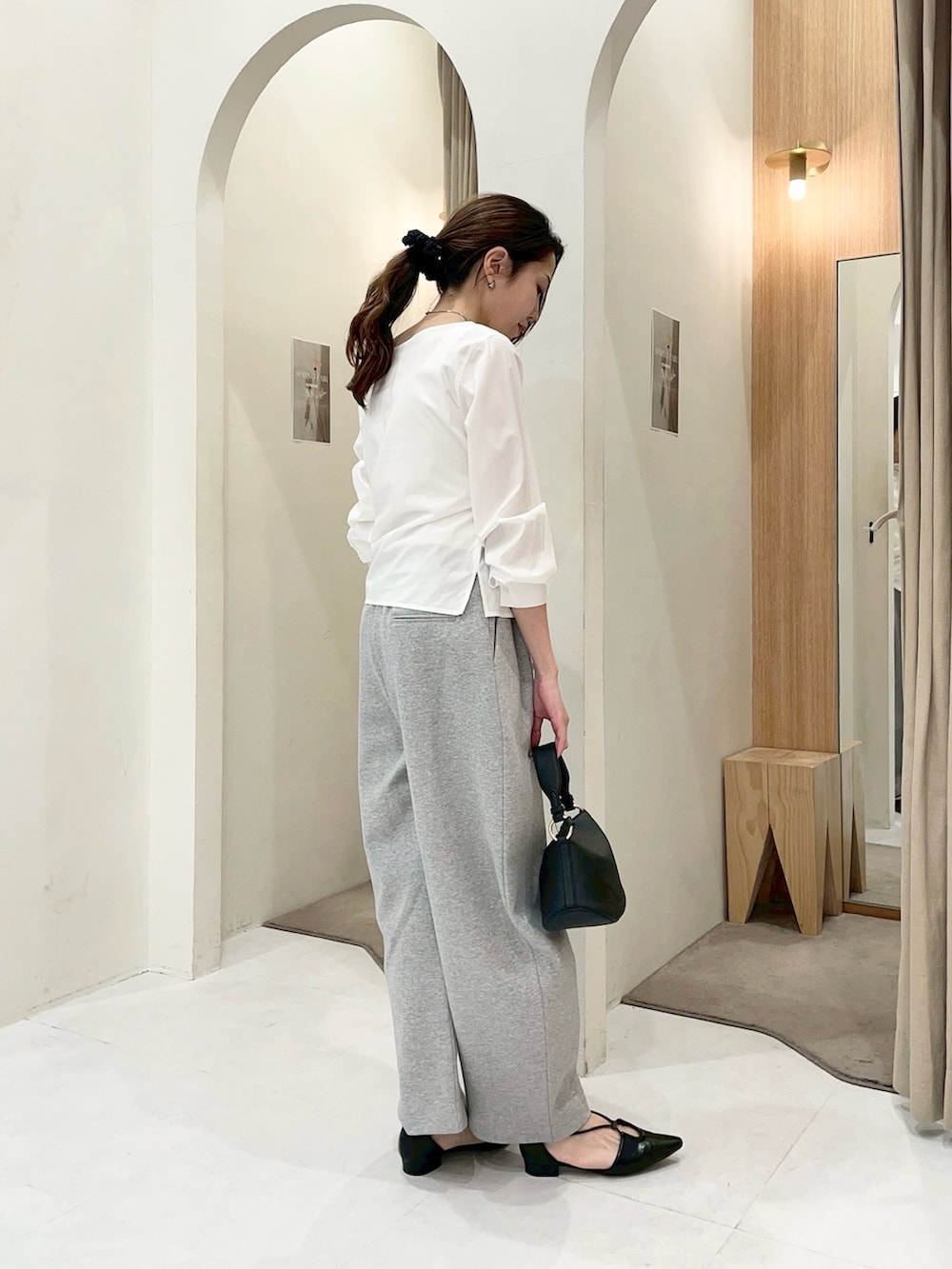 ホワイト系のシャツ/ブラウス、グレー系のその他パンツ、ブラック系のショルダーバッグを着用したレディースの春コーディネートの3枚目の写真