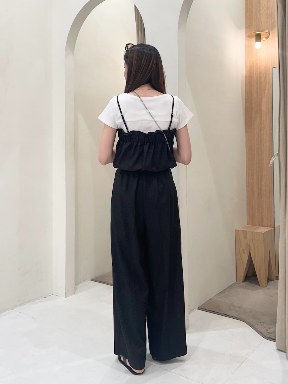 ブラック系のショルダーバッグ、ブラック系のつなぎ/オールインワン、ブラック系のパンプスを着用したレディースの夏コーディネートの2枚目の写真