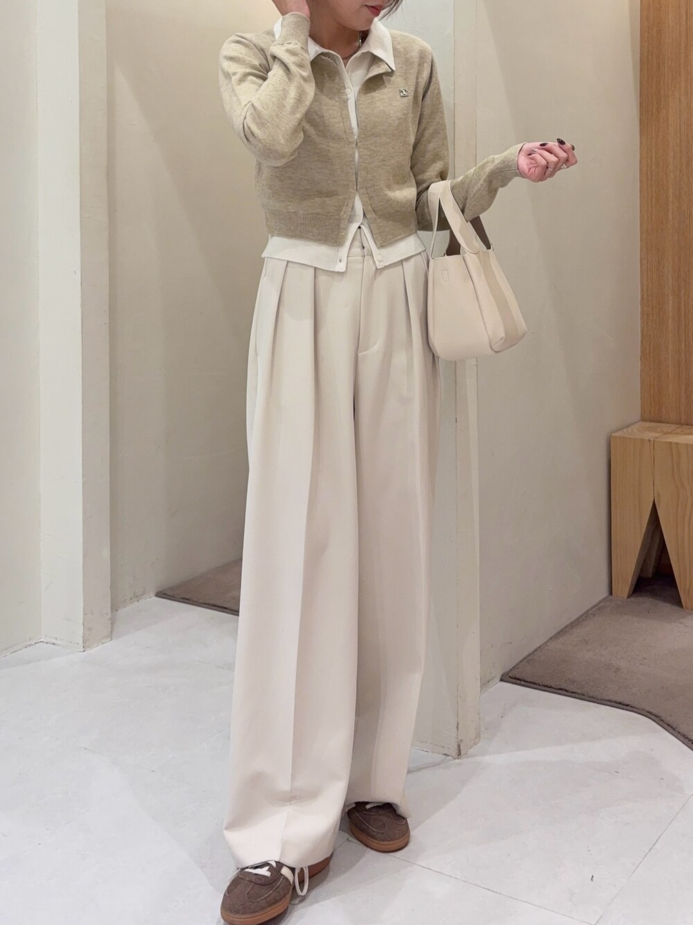 ベージュ系のカーディガン/ボレロ、ホワイト系のその他パンツ、ホワイト系のショルダーバッグを着用したレディースの冬コーディネートの5枚目の写真