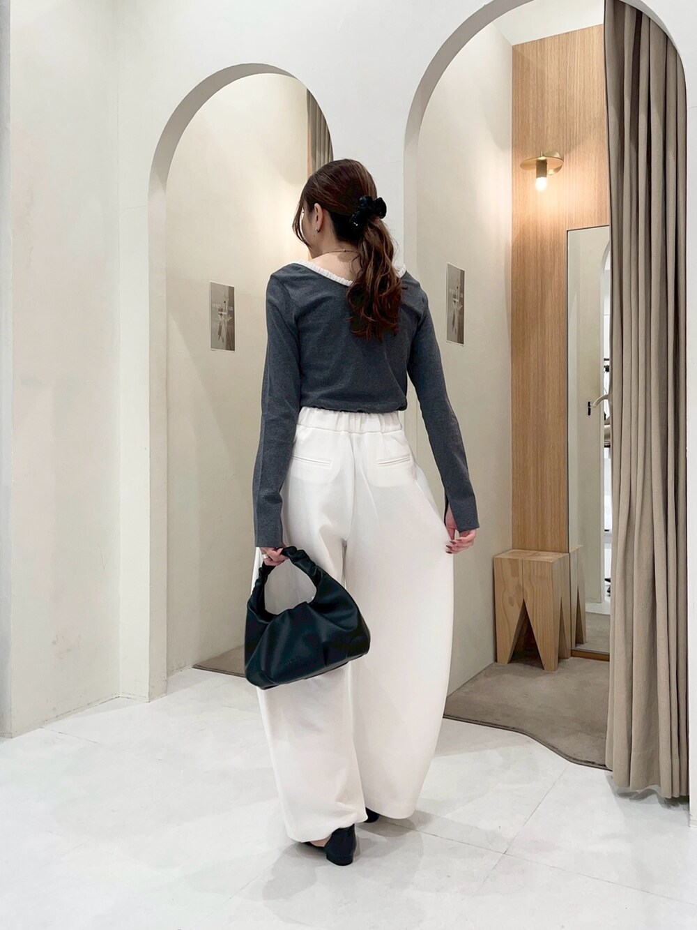 グレー系のTシャツ/カットソー、ホワイト系のその他パンツ、ブラック系のショルダーバッグを着用したレディースの春コーディネートの2枚目の写真
