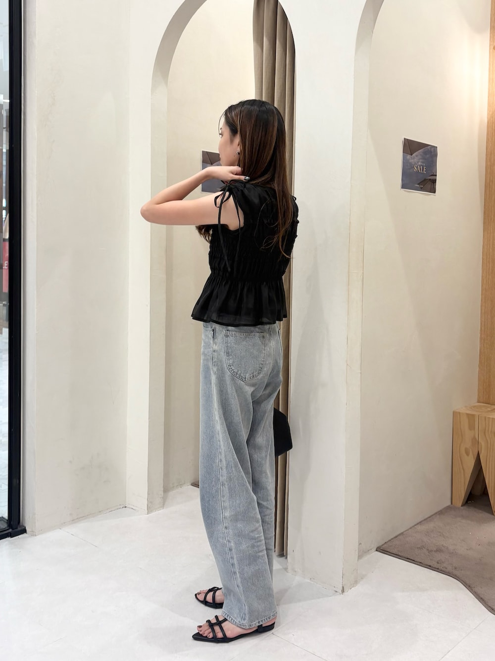 ブラック系のシャツ/ブラウス、ブラック系のショルダーバッグ、ブルー系のデニムパンツを着用したレディースの夏コーディネートの2枚目の写真