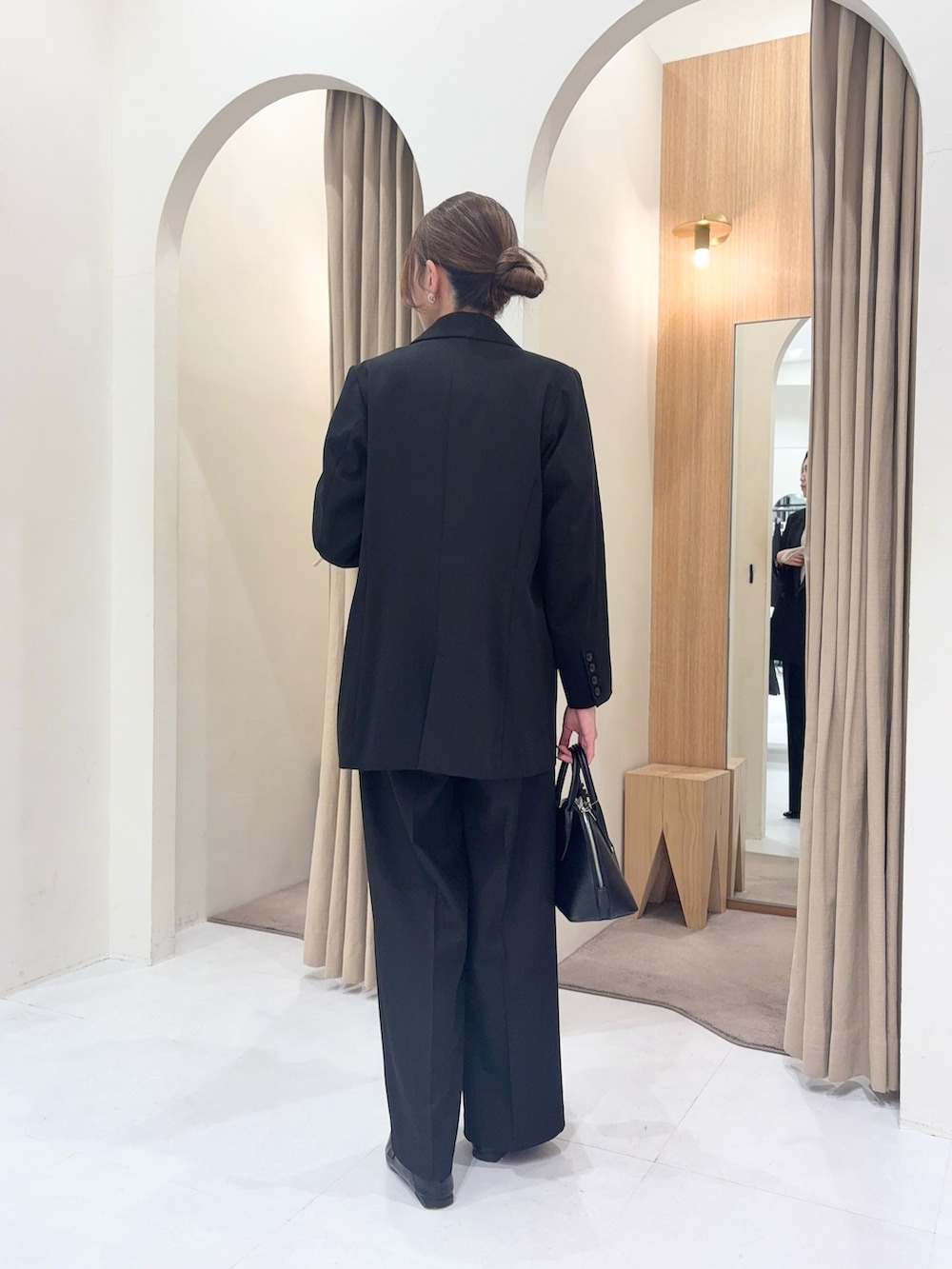 ブラック系のテーラードジャケット、ブラック系のその他パンツ、ブラック系のショルダーバッグを着用したレディースの春コーディネートの4枚目の写真