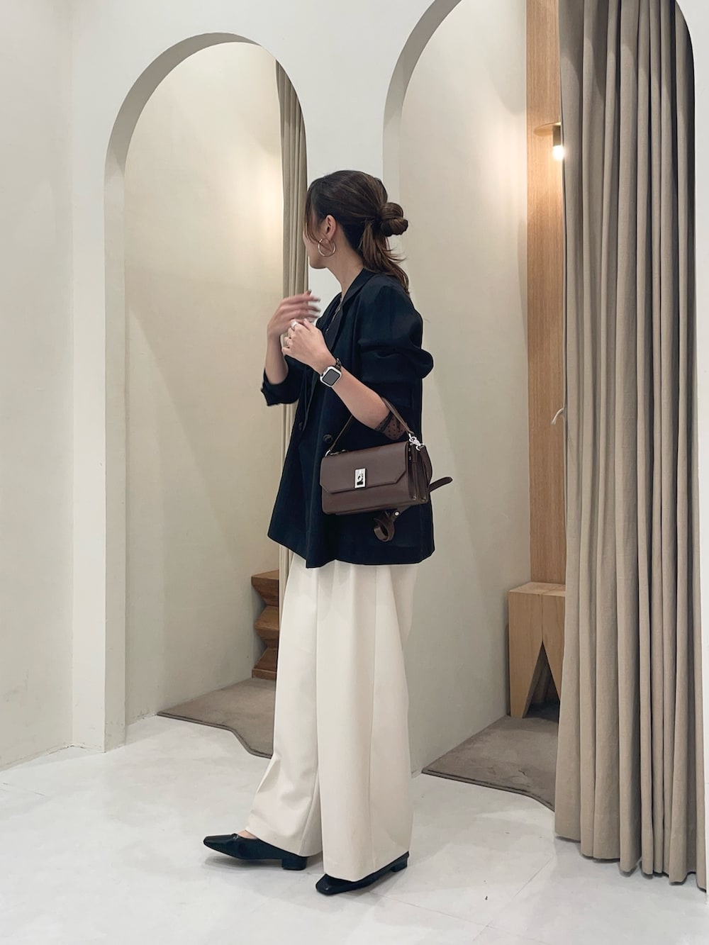 ブラウン系のショルダーバッグ、ブラック系のテーラードジャケット、ブラック系のシャツ/ブラウスを着用したレディースの秋コーディネートの2枚目の写真