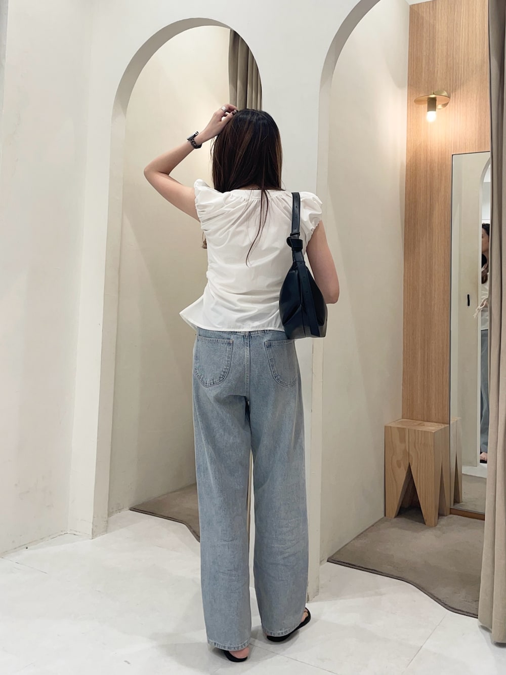 ホワイト系のシャツ/ブラウス、ブルー系のデニムパンツ、ブラック系のショルダーバッグを着用したレディースの夏コーディネートの3枚目の写真