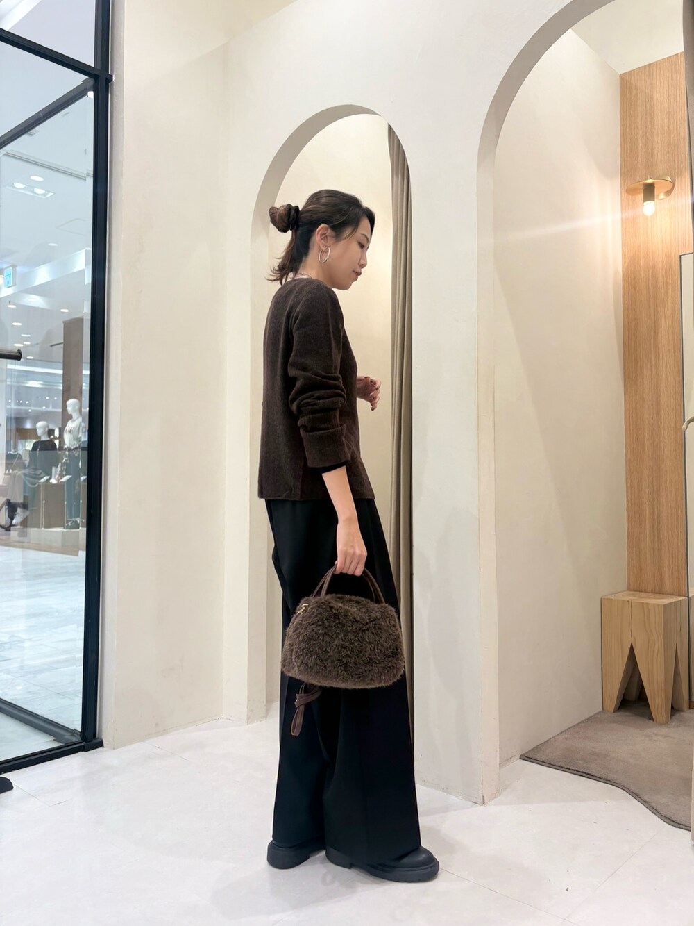 ブラウン系のカーディガン/ボレロ、ブラウン系のボストンバッグ、ブラック系のその他パンツを着用したレディースの秋コーディネートの3枚目の写真