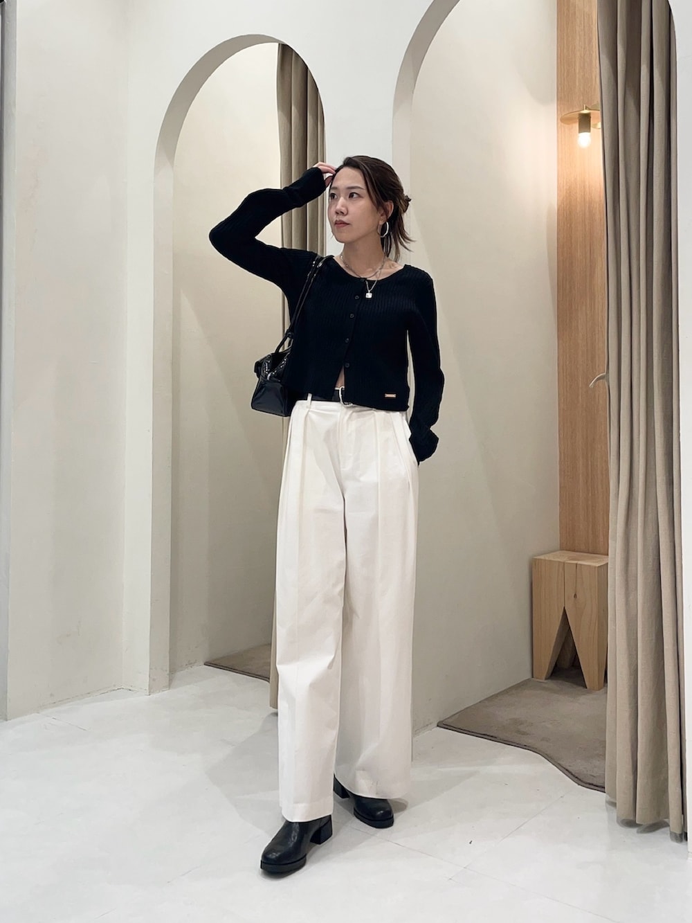 ブラック系のブルゾン、ブラック系のカーディガン/ボレロ、ホワイト系のその他パンツを着用したレディースの秋コーディネートの2枚目の写真