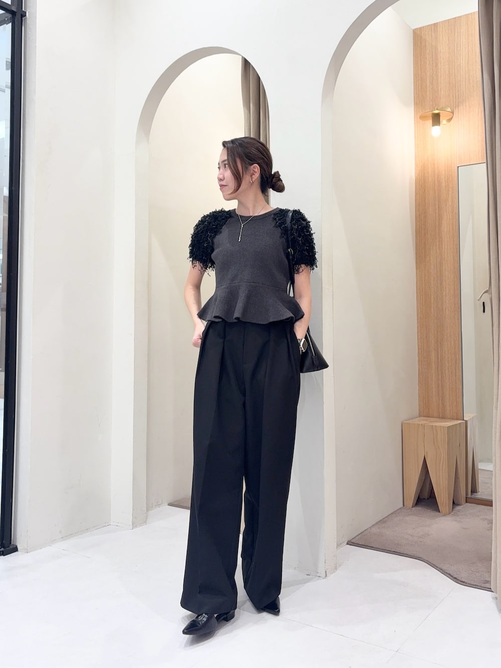 ブラック系のショルダーバッグ、グレー系のニット/セーター、ブラック系のその他パンツを着用したレディースの春コーディネートの4枚目の写真