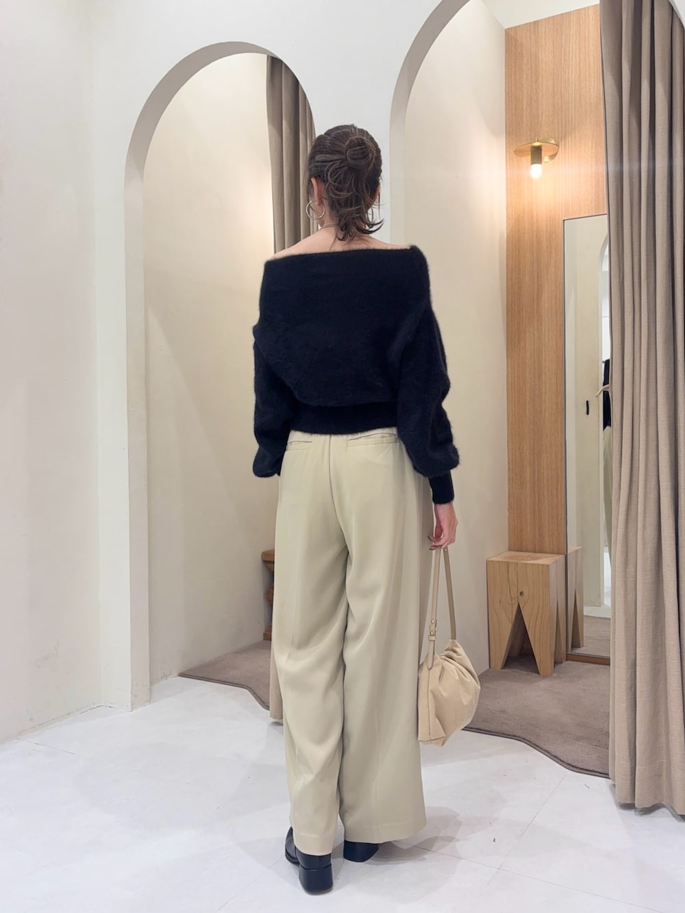 ブラック系のニット/セーター、ホワイト系のショルダーバッグ、ベージュ系のその他パンツを着用したレディースの秋コーディネートの2枚目の写真