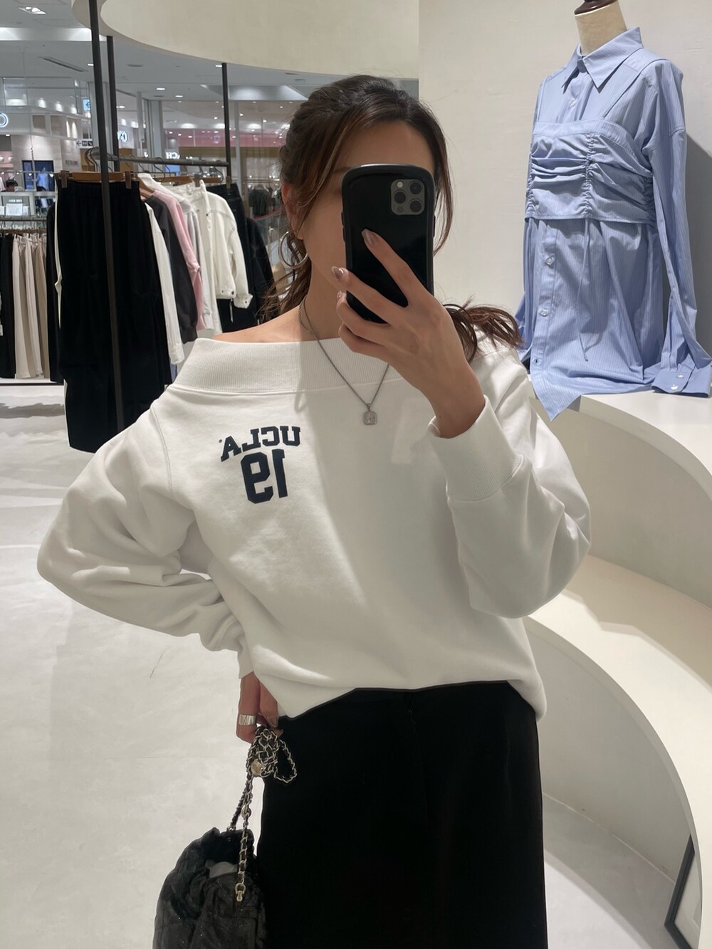 ホワイト系のTシャツ/カットソー、ブラック系のスカート、ブラック系のショルダーバッグを着用したレディースの冬コーディネートの3枚目の写真
