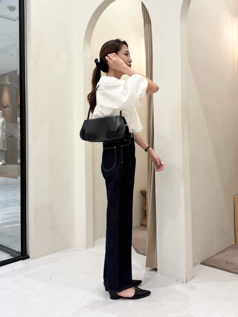 ブラック系のショルダーバッグ、ホワイト系のシャツ/ブラウス、ブラック系のデニムパンツを着用したレディースの春コーディネートの4枚目の写真