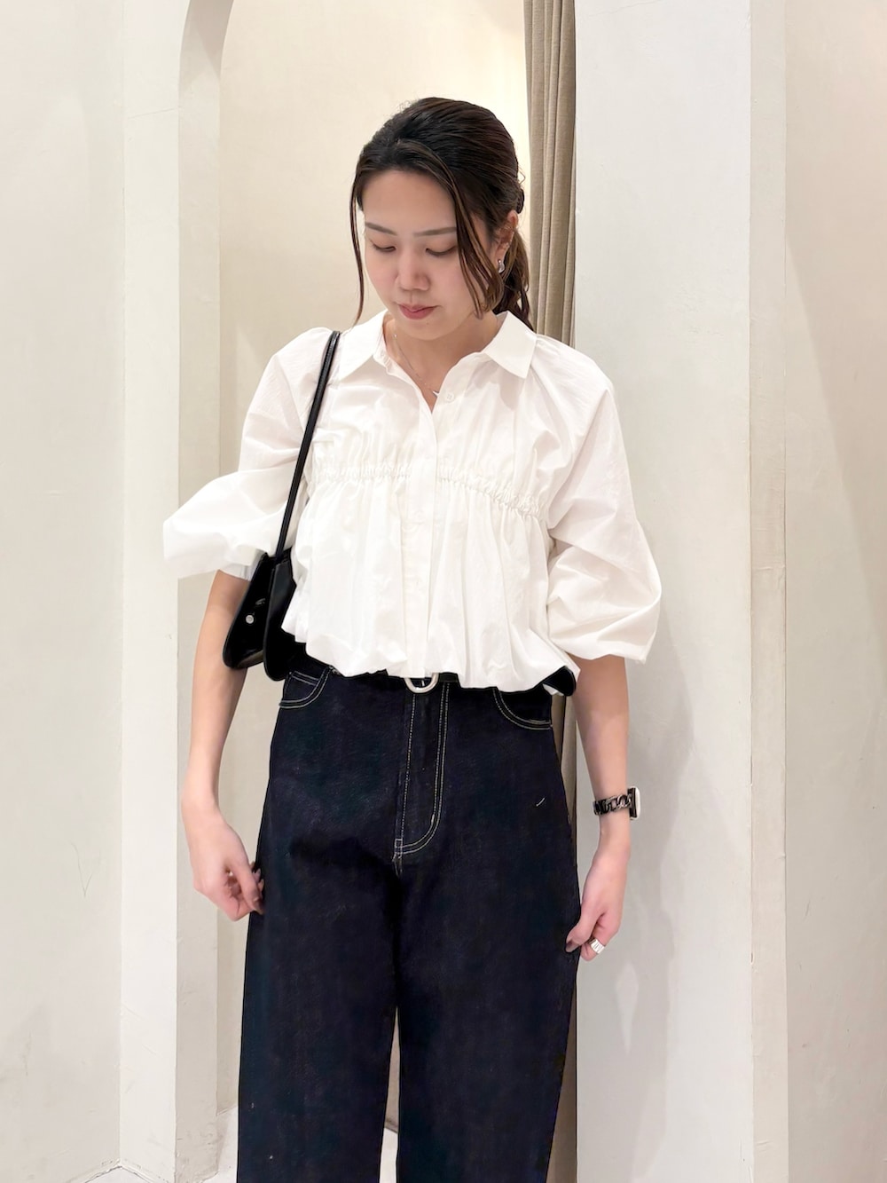 ブラック系のショルダーバッグ、ホワイト系のシャツ/ブラウス、ブラック系のデニムパンツを着用したレディースの春コーディネートの5枚目の写真