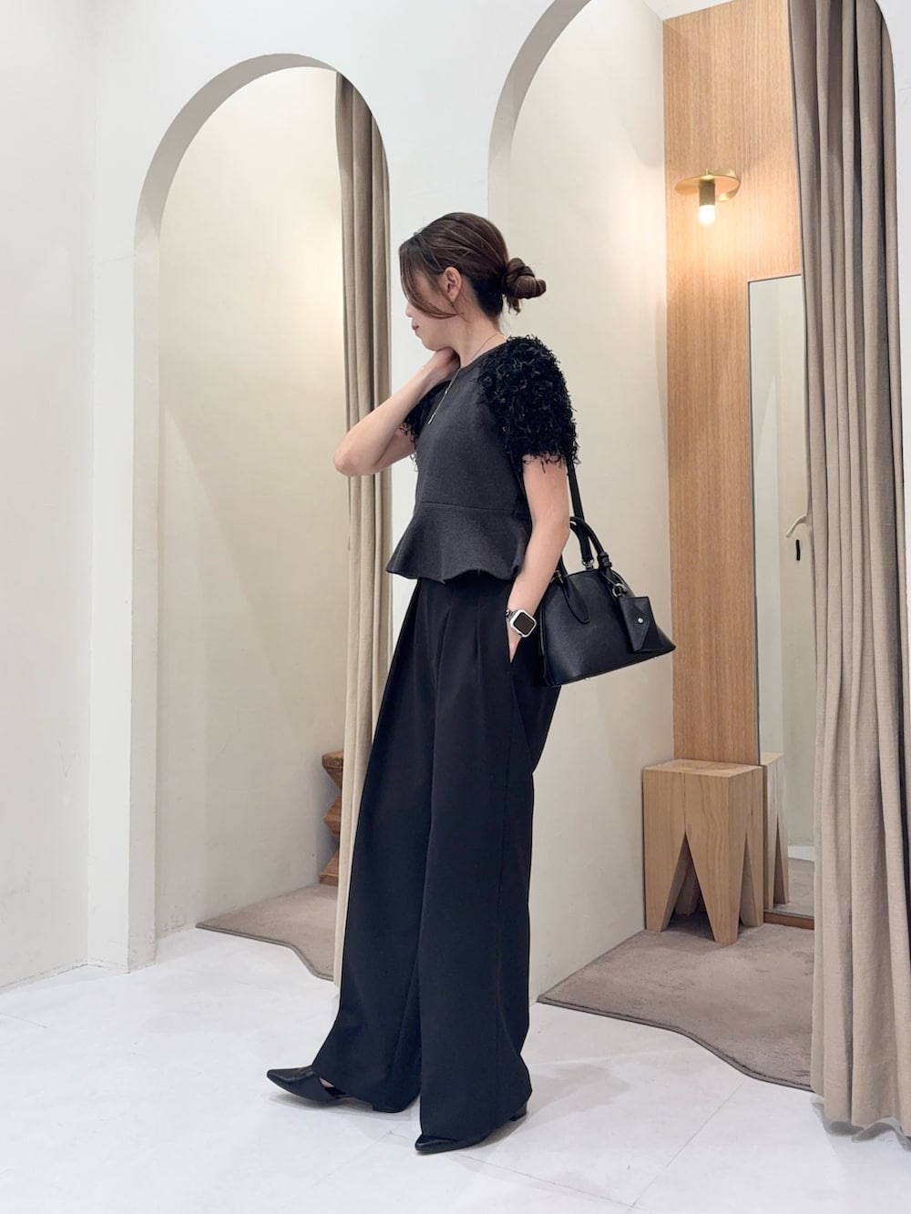 ブラック系のショルダーバッグ、グレー系のニット/セーター、ブラック系のその他パンツを着用したレディースの春コーディネートの2枚目の写真