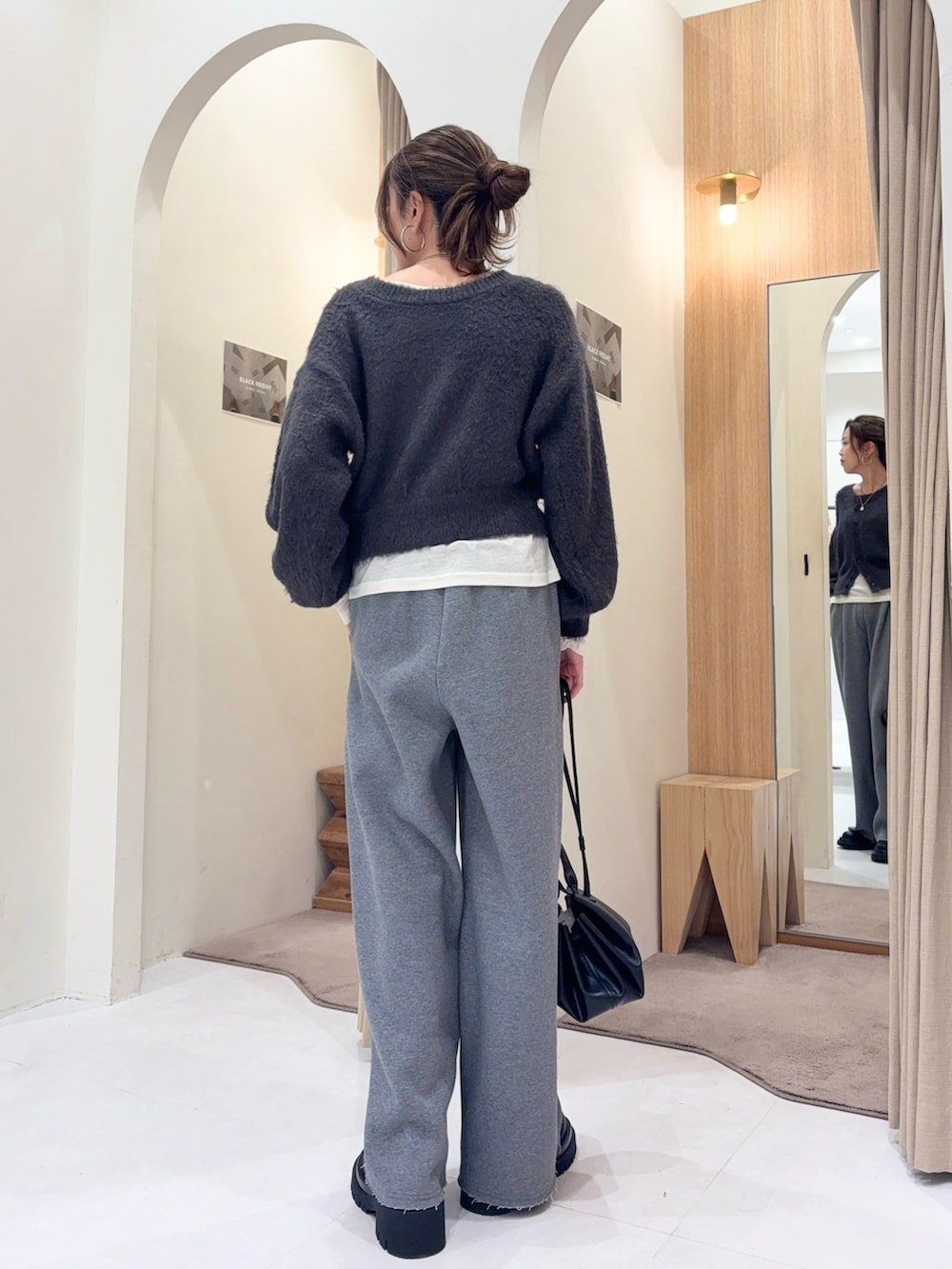 グレー系のカーディガン/ボレロ、ホワイト系のTシャツ/カットソー、ブラック系のショルダーバッグを着用したレディースの冬コーディネートの2枚目の写真