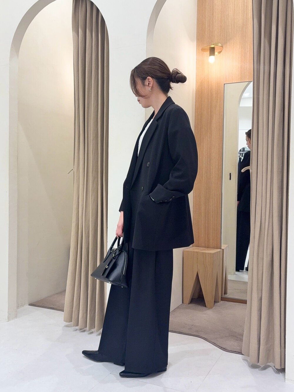 ブラック系のテーラードジャケット、ブラック系のその他パンツ、ブラック系のショルダーバッグを着用したレディースの春コーディネートの3枚目の写真