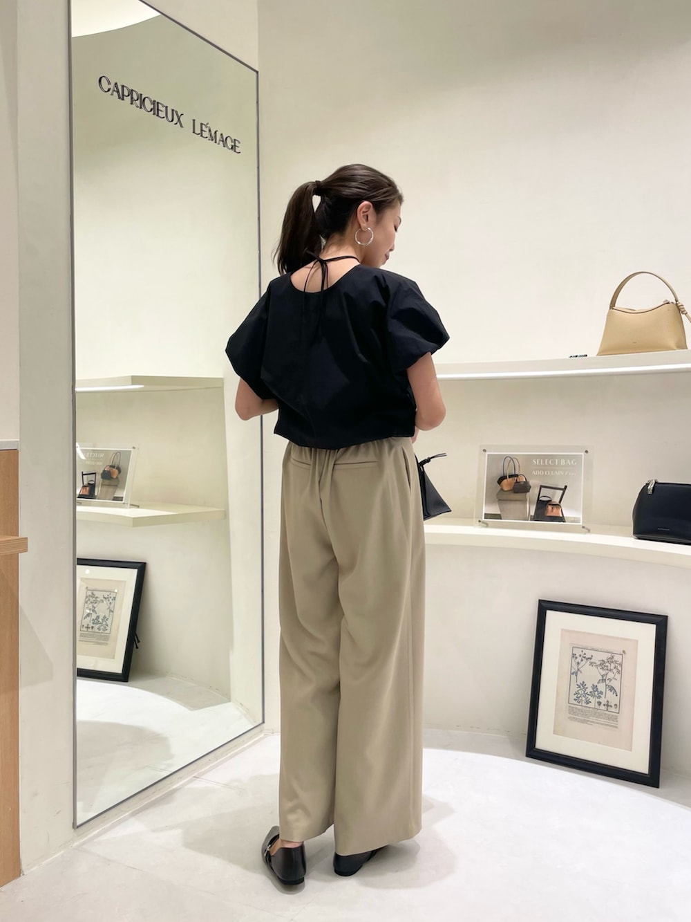 ブラック系のシャツ/ブラウス、ブラック系のショルダーバッグ、ベージュ系のその他パンツを着用したレディースの春コーディネートの3枚目の写真