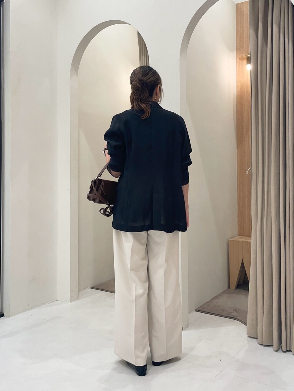 ブラウン系のショルダーバッグ、ブラック系のテーラードジャケット、ブラック系のシャツ/ブラウスを着用したレディースの秋コーディネートの3枚目の写真