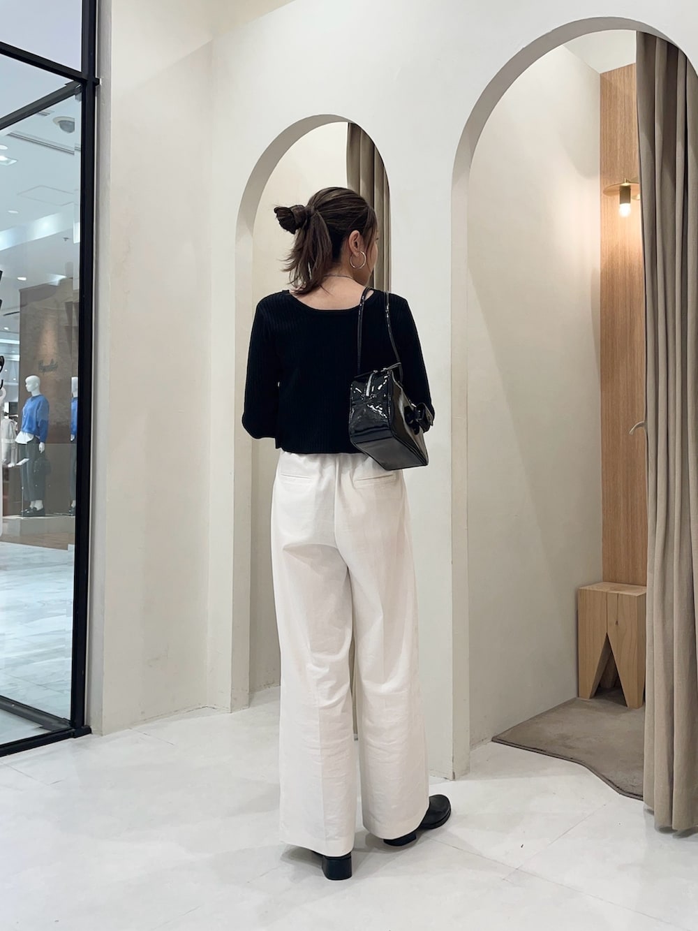 ブラック系のブルゾン、ブラック系のカーディガン/ボレロ、ホワイト系のその他パンツを着用したレディースの秋コーディネートの3枚目の写真