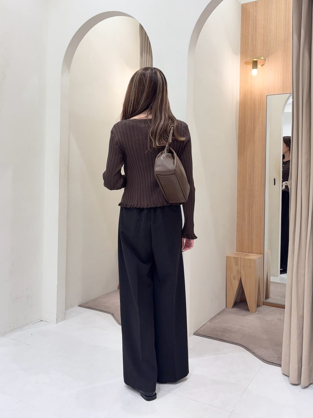 ブラウン系のカーディガン/ボレロ、ブラウン系のショルダーバッグ、ブラック系のその他パンツを着用したレディースの秋コーディネートの2枚目の写真