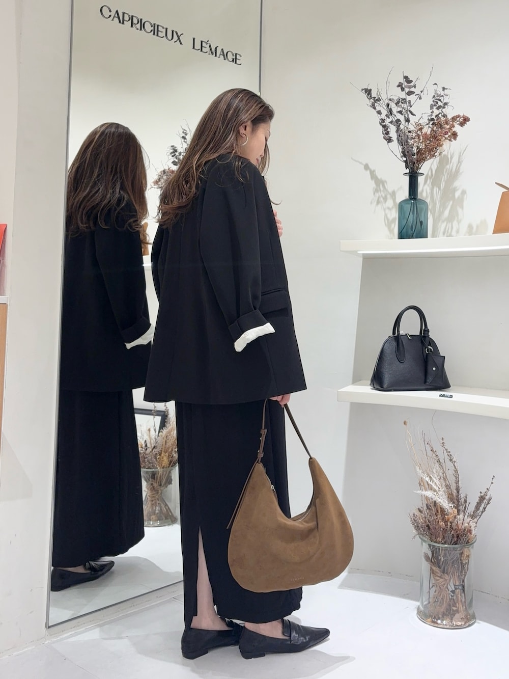 ホワイト系のTシャツ/カットソー、ブラック系のテーラードジャケット、ブラック系のスカートを着用したレディースの春コーディネートの4枚目の写真