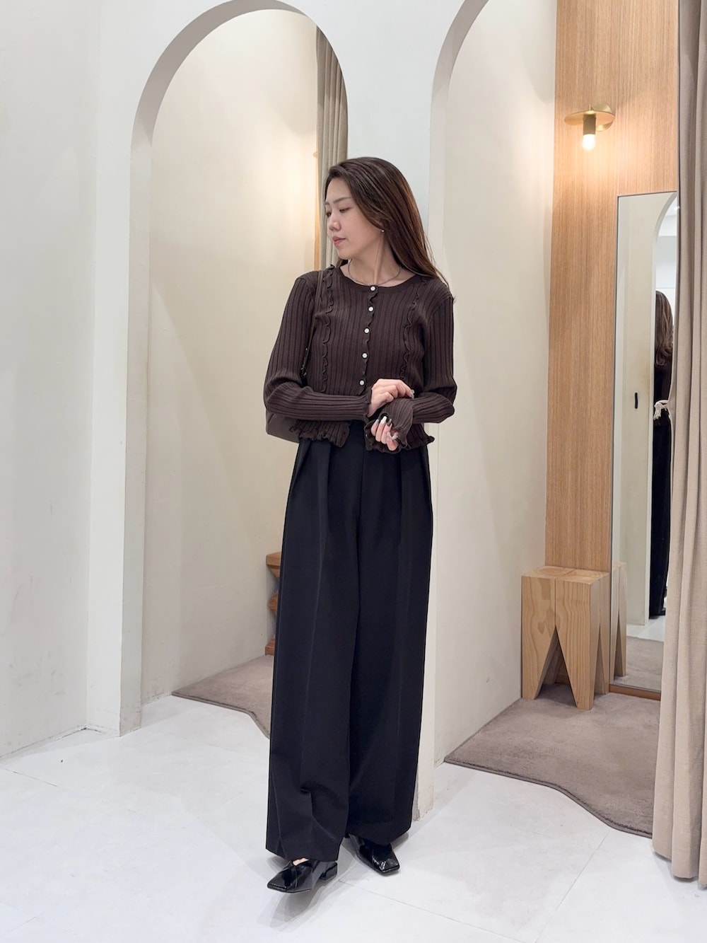 ブラウン系のカーディガン/ボレロ、ブラウン系のショルダーバッグ、ブラック系のその他パンツを着用したレディースの秋コーディネートの4枚目の写真