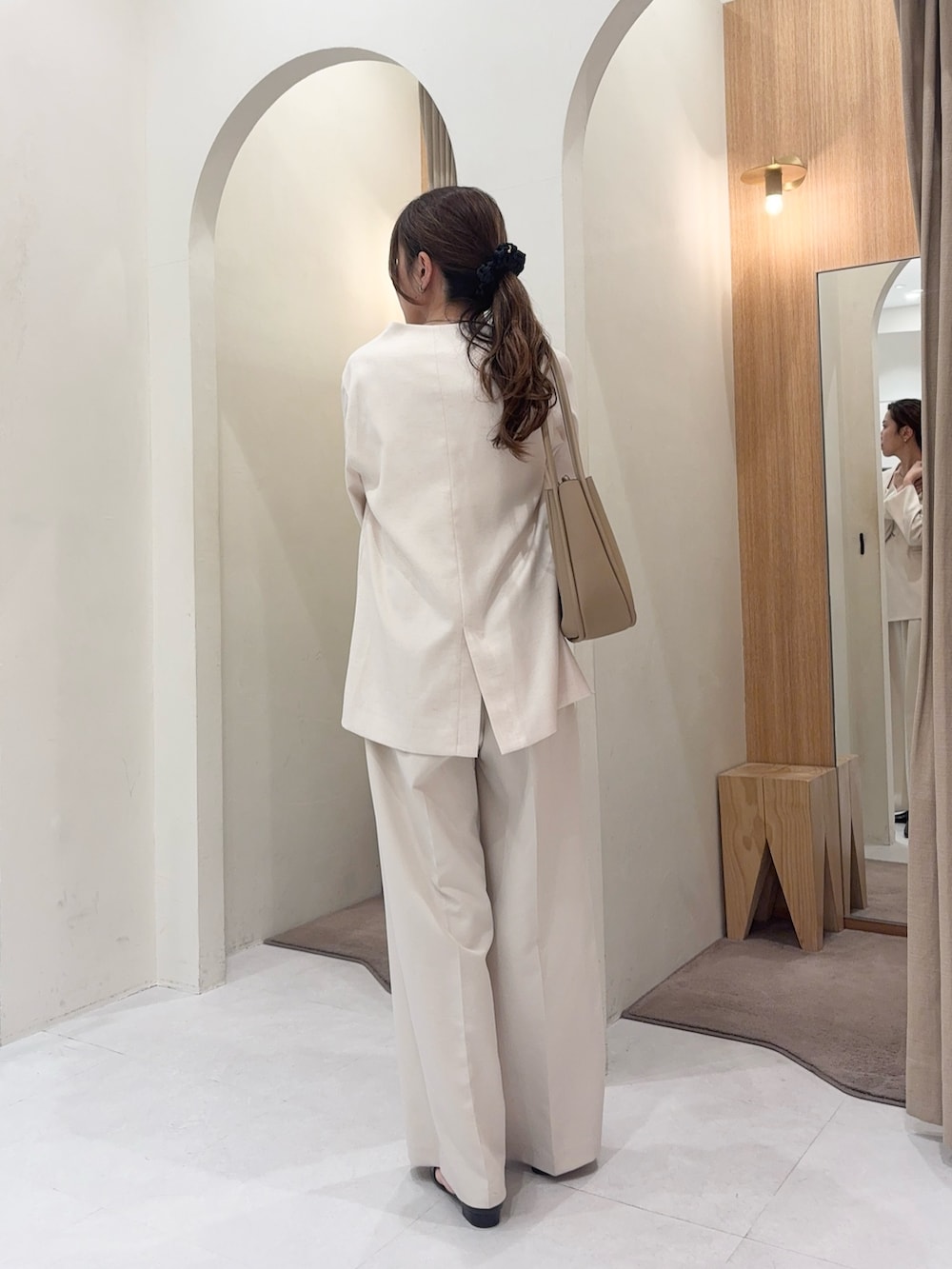 ホワイト系のその他アウター、ホワイト系のその他パンツ、ベージュ系のショルダーバッグを着用したレディースの春コーディネートの2枚目の写真