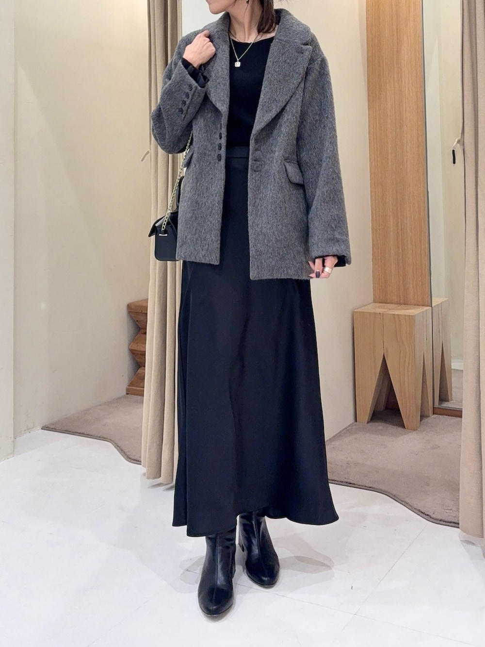 ブラック系のニット/セーター、グレー系のその他アウター、ブラック系のスカートを着用したレディースの冬コーディネートの2枚目の写真