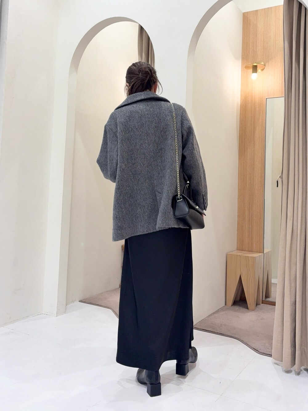 ブラック系のニット/セーター、グレー系のその他アウター、ブラック系のスカートを着用したレディースの冬コーディネートの3枚目の写真