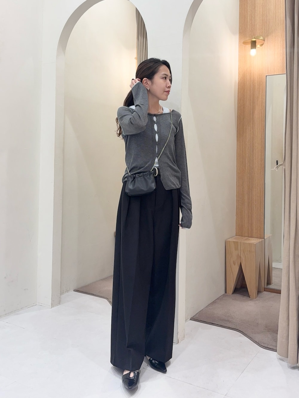 グレー系のカーディガン/ボレロ、ブラック系のショルダーバッグ、ブラック系のその他パンツを着用したレディースの春コーディネートの2枚目の写真