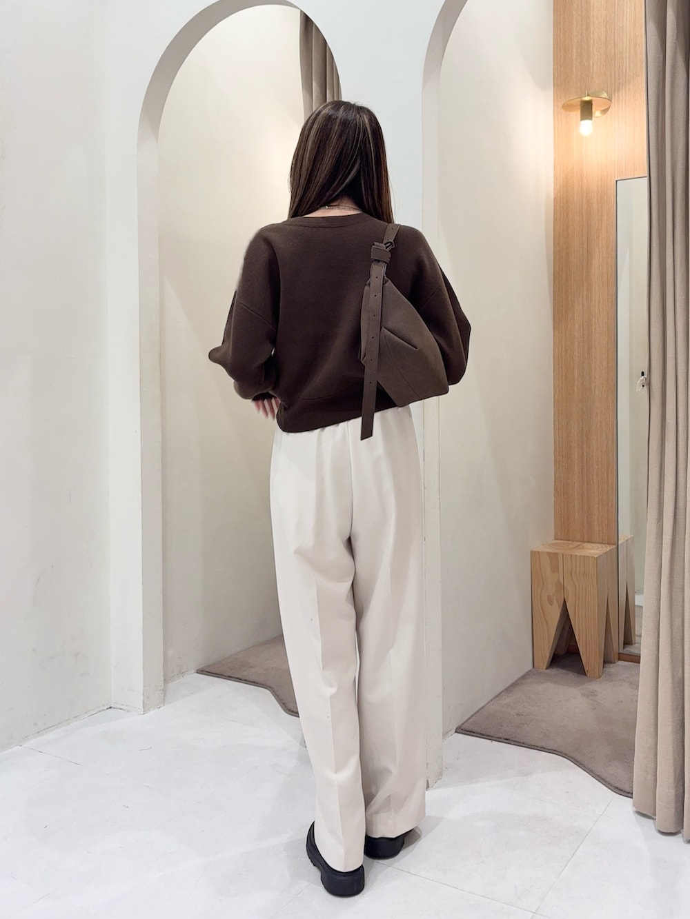 ブラウン系のニット/セーター、ブラウン系のトートバッグ、ホワイト系のその他パンツを着用したレディースの秋コーディネートの3枚目の写真