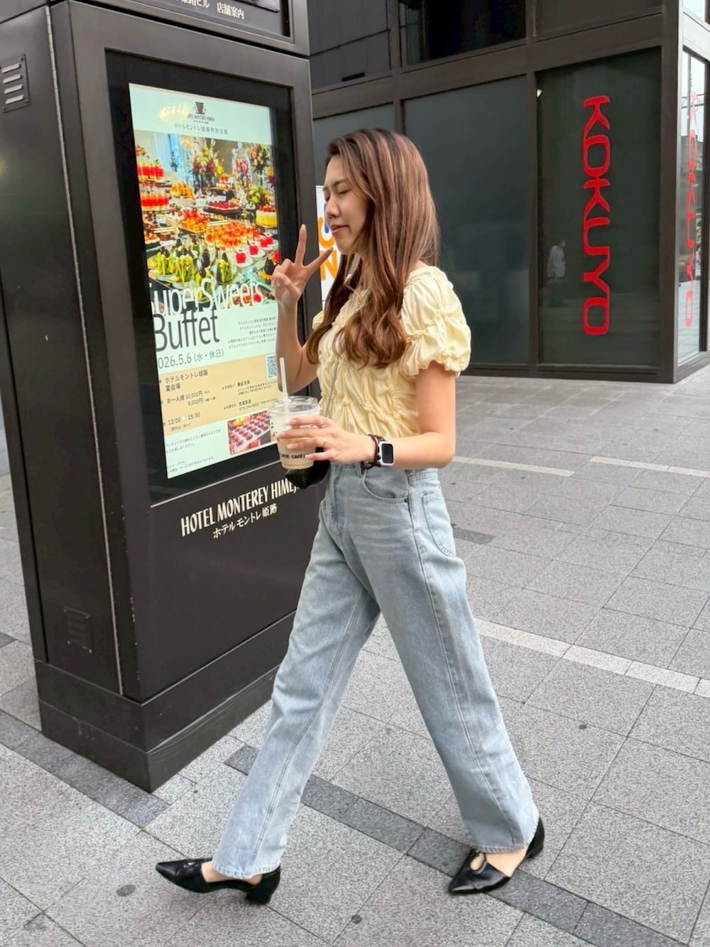 イエロー系のTシャツ/カットソー、ブラック系のショルダーバッグ、ブルー系のデニムパンツを着用したレディースの春コーディネートの3枚目の写真