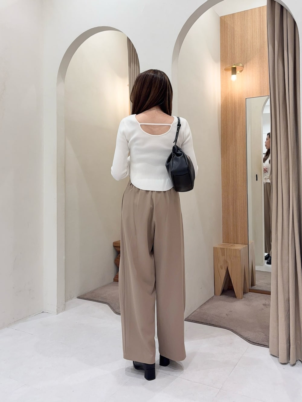 ホワイト系のニット/セーター、ブラック系のショルダーバッグ、ベージュ系のその他パンツを着用したレディースの秋コーディネートの2枚目の写真