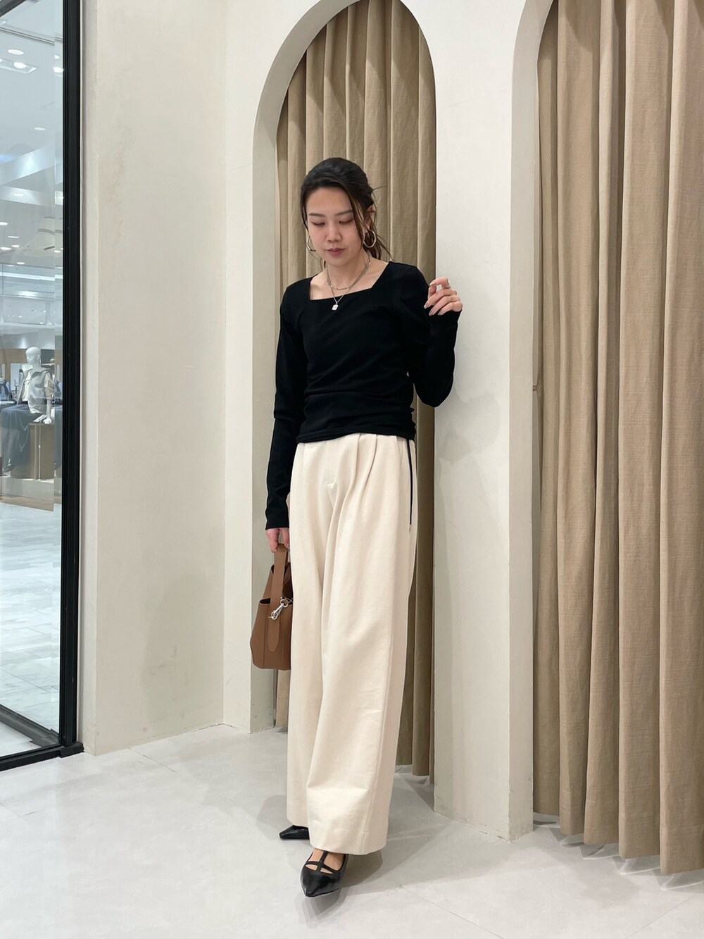 ブラック系のTシャツ/カットソー、ホワイト系のその他パンツ、ブラウン系のショルダーバッグを着用したレディースの春コーディネートの2枚目の写真