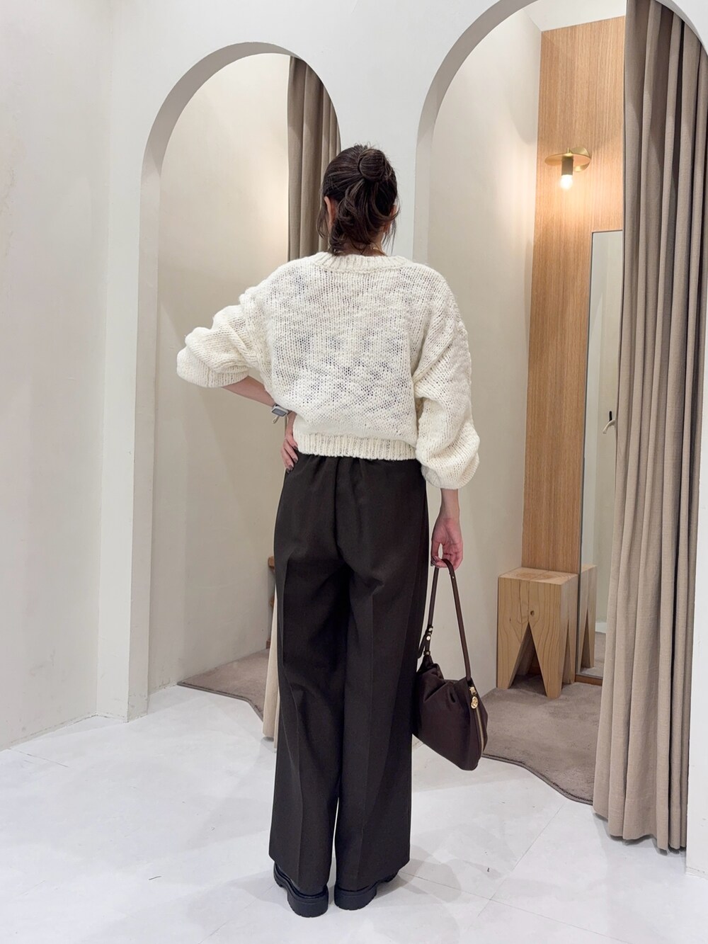 ホワイト系のニット/セーター、ブラウン系のその他パンツ、ブラウン系のショルダーバッグを着用したレディースの秋コーディネートの2枚目の写真
