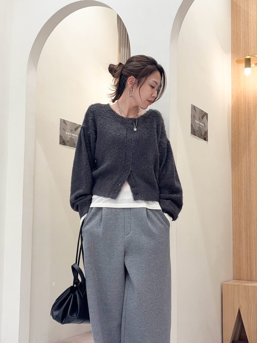 グレー系のカーディガン/ボレロ、ホワイト系のTシャツ/カットソー、ブラック系のショルダーバッグを着用したレディースの冬コーディネートの4枚目の写真