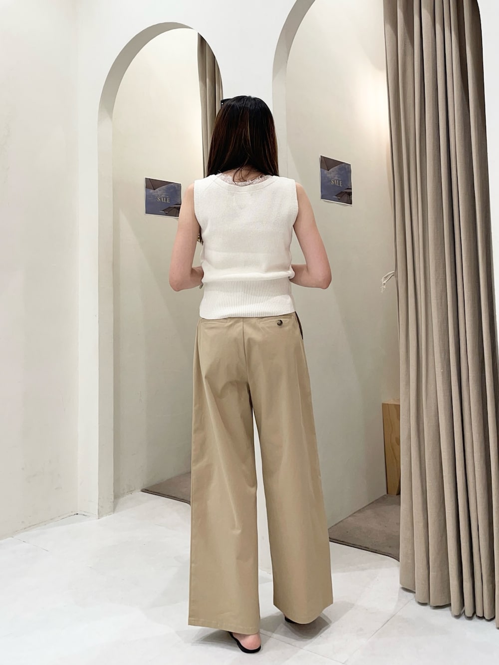 ホワイト系のニット/セーター、ベージュ系のその他パンツ、ブラック系のパンプスを着用したレディースの夏コーディネートの3枚目の写真