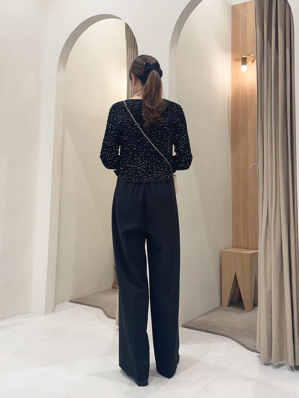 ホワイト系のショルダーバッグ、ブラック系のシャツ/ブラウス、ブラック系のその他パンツを着用したレディースの冬コーディネートの2枚目の写真