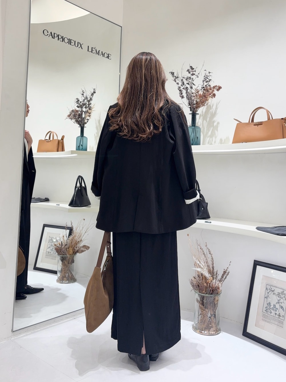 ホワイト系のTシャツ/カットソー、ブラック系のテーラードジャケット、ブラック系のスカートを着用したレディースの春コーディネートの3枚目の写真