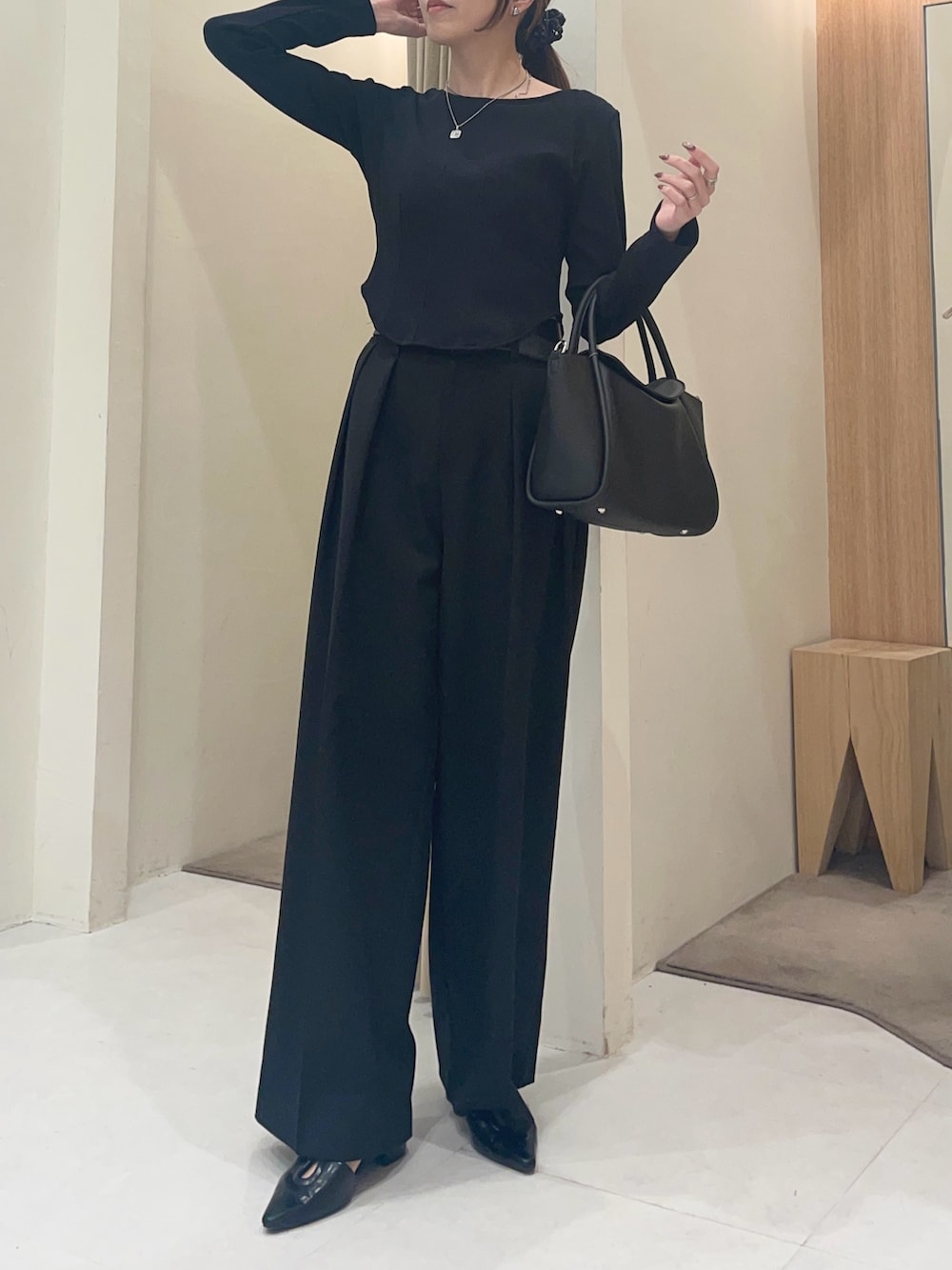 ブラック系のTシャツ/カットソー、ブラック系のパンプス、ブラック系のショルダーバッグを着用したレディースの春コーディネートの4枚目の写真