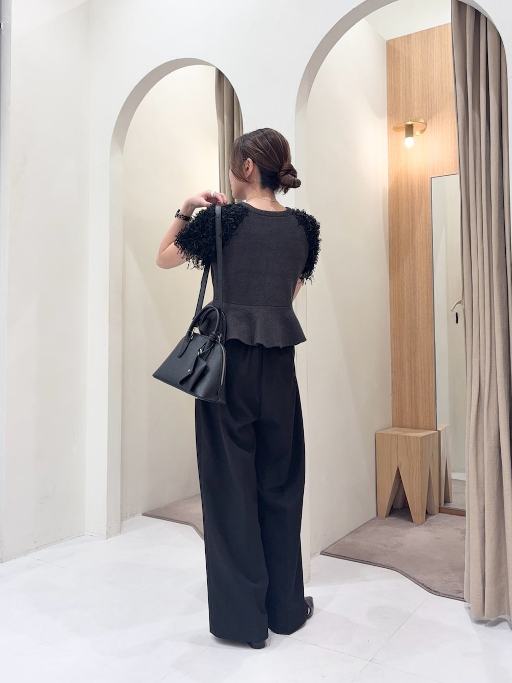 ブラック系のショルダーバッグ、グレー系のニット/セーター、ブラック系のその他パンツを着用したレディースの春コーディネートの3枚目の写真