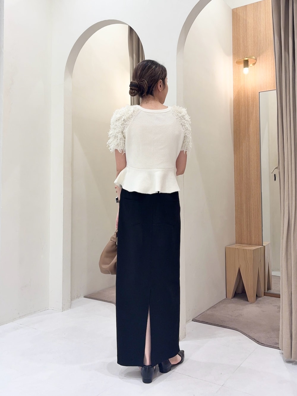 ホワイト系のニット/セーター、イエロー系のショルダーバッグ、ブラック系のスカートを着用したレディースの春コーディネートの3枚目の写真