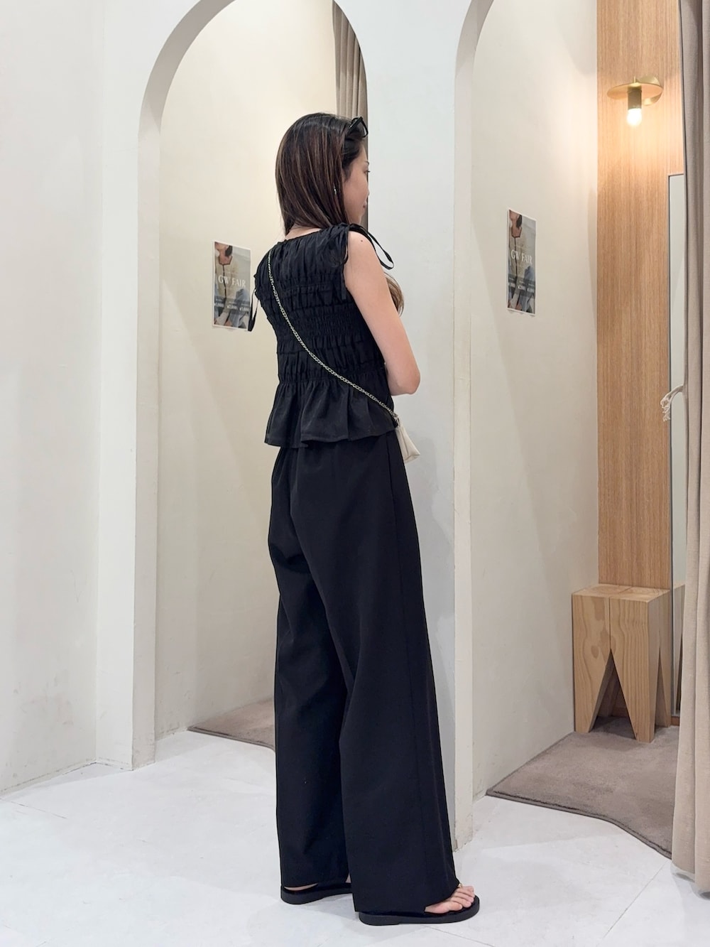 ブラック系のシャツ/ブラウス、ホワイト系のショルダーバッグ、ブラック系のその他パンツを着用したレディースの春コーディネートの2枚目の写真