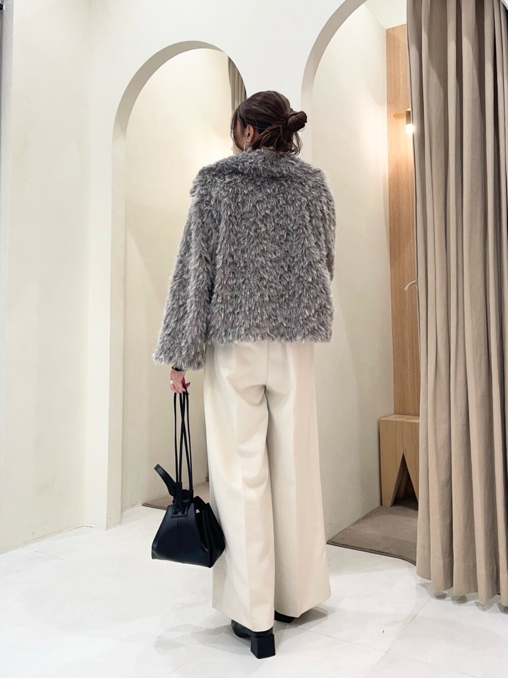 ブラック系のカーディガン/ボレロ、グレー系のその他アウター、ホワイト系のその他パンツを着用したレディースの冬コーディネートの3枚目の写真