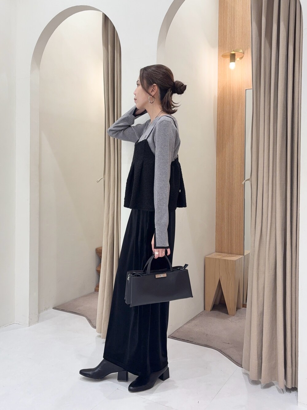 グレー系のニット/セーター、ブラック系のシャツ/ブラウス、ブラック系のスカートを着用したレディースの冬コーディネートの2枚目の写真