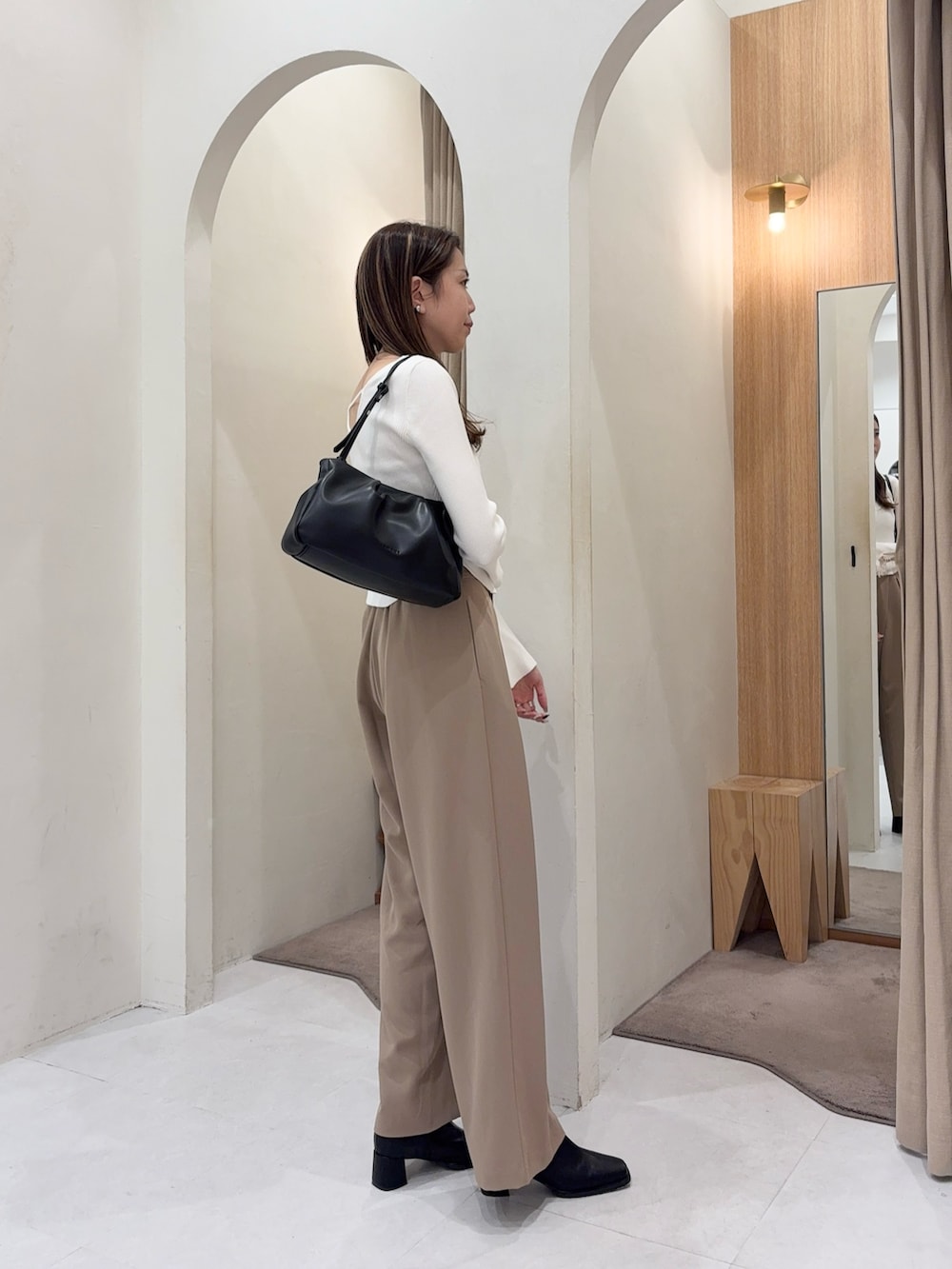 ホワイト系のニット/セーター、ブラック系のショルダーバッグ、ベージュ系のその他パンツを着用したレディースの秋コーディネートの3枚目の写真