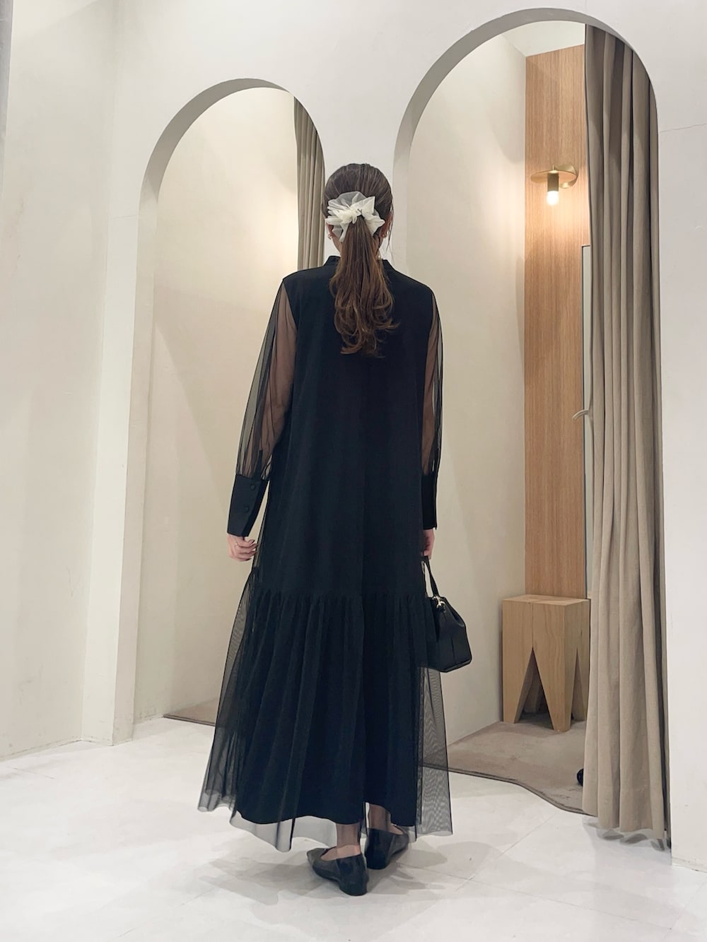 ブラック系のショルダーバッグ、ブラック系のパンプス、ブラック系のワンピースを着用したレディースの春コーディネートの2枚目の写真