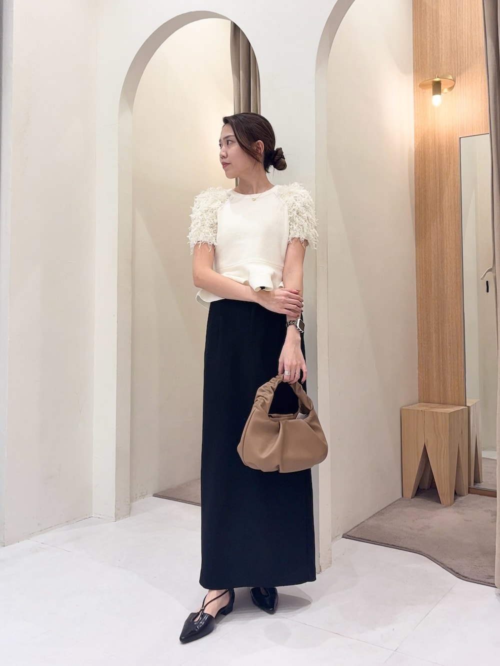 ホワイト系のニット/セーター、イエロー系のショルダーバッグ、ブラック系のスカートを着用したレディースの春コーディネートの4枚目の写真