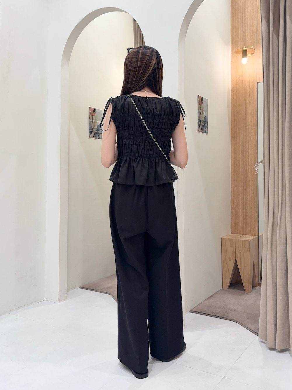 ブラック系のシャツ/ブラウス、ホワイト系のショルダーバッグ、ブラック系のその他パンツを着用したレディースの春コーディネートの3枚目の写真